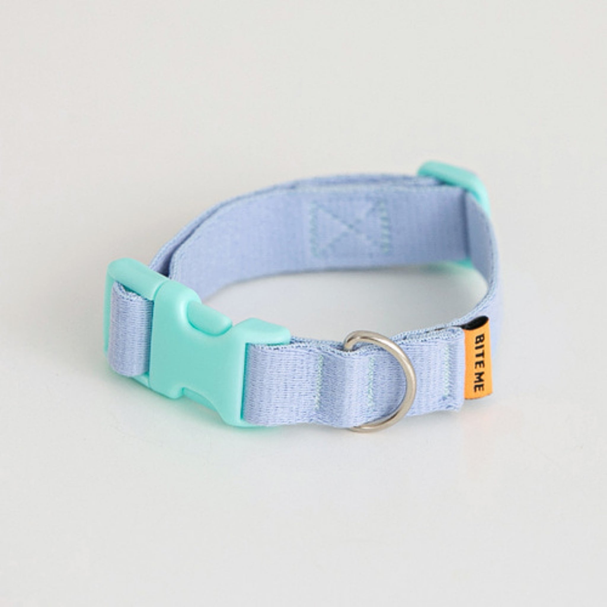 A close-up view of the pastel light blue Bite Me Candy Crayon dog collar, highlighting the mint green ergonomic buckle and durable woven fabric texture.
