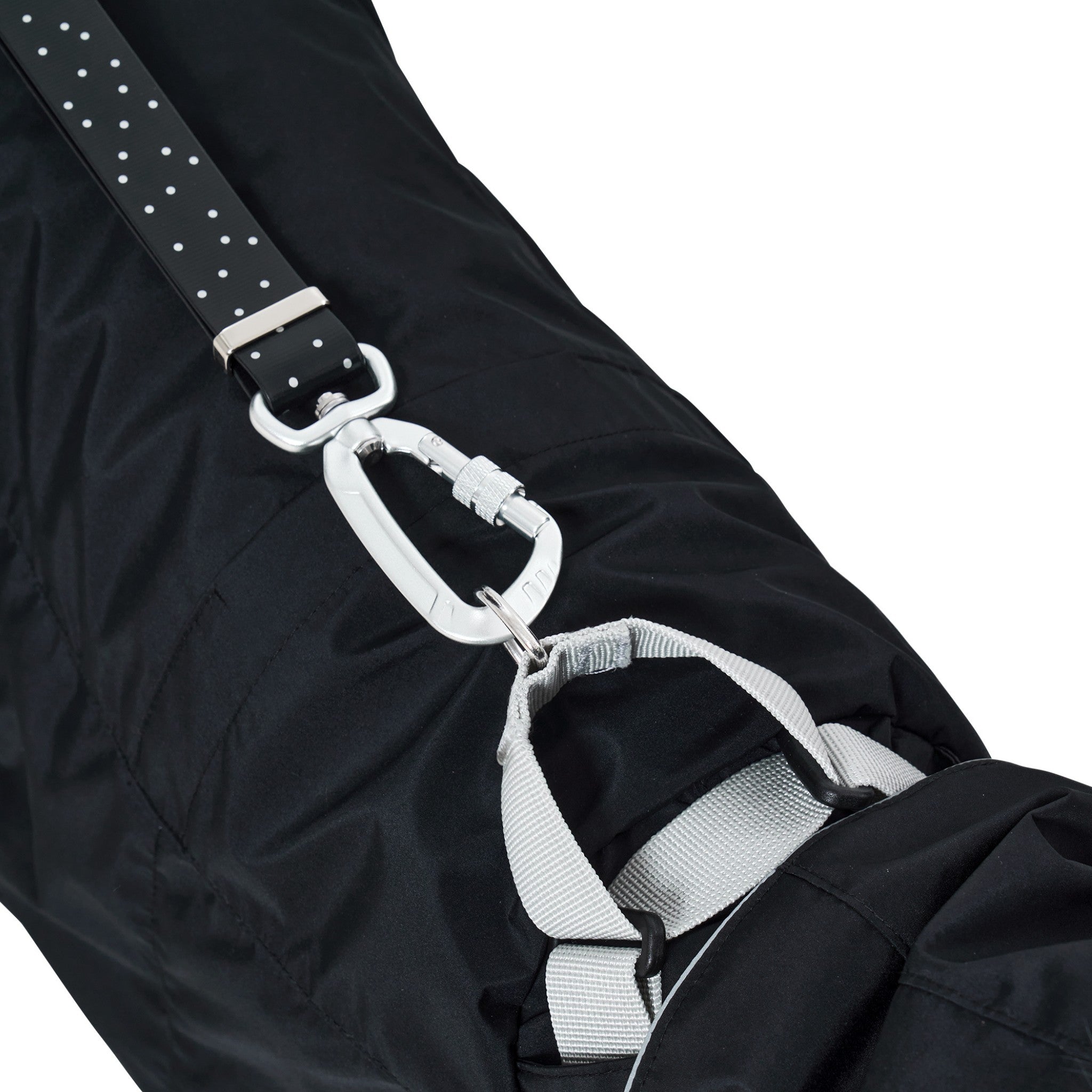 An extreme close-up of the durable silver metal carabiner clip attached to the heavy-duty grey nylon harness strap on the back of the black Merlot Ain™ dog raincoat.
