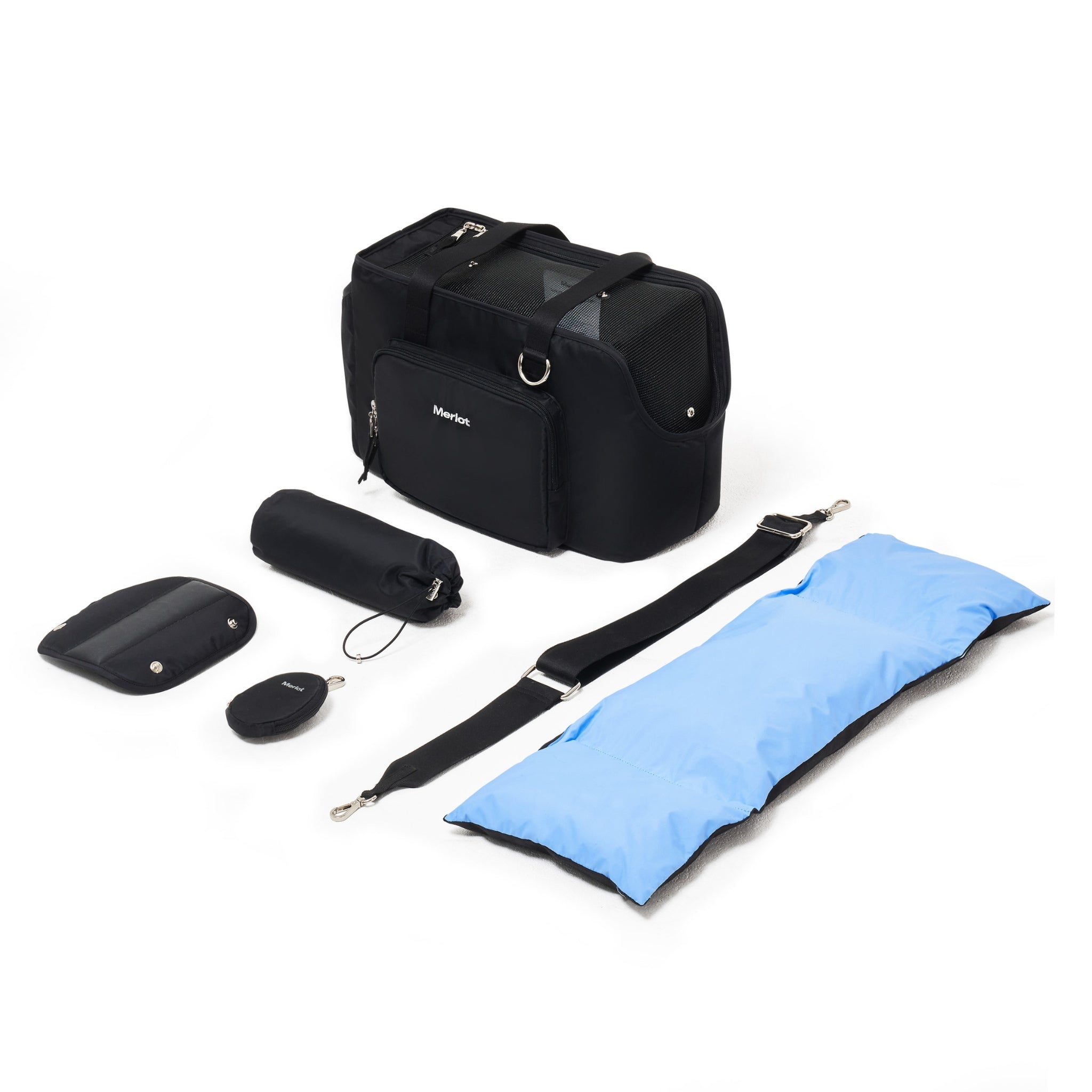 An overhead flat lay displaying the complete black Merlot Mermer dog carrier bag set, including the main travel tote, blue-black reversible cushion, cross strap, shoulder pad, and matching accessory pouches.