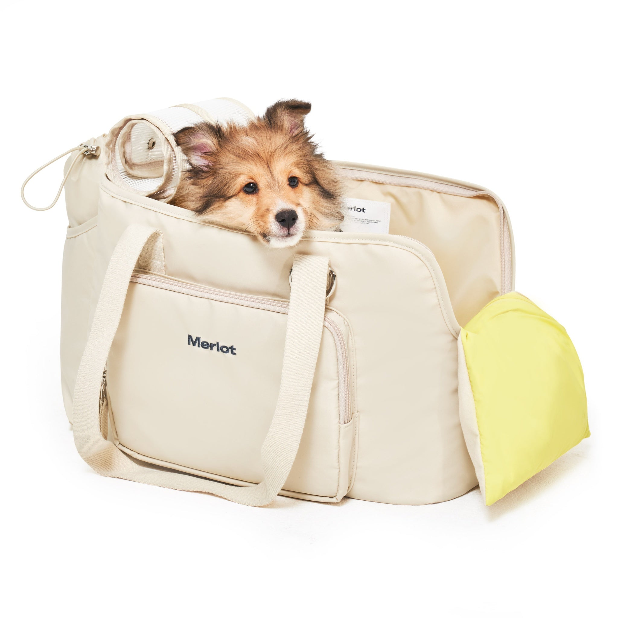 A fluffy brown puppy resting contentedly inside the lemon cream Merlot Mermer pet travel tote bag, peering over the edge from the open mesh top canopy.