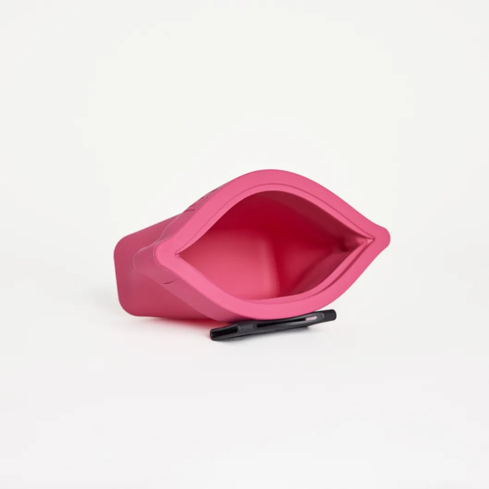 An open fuchsia pink silicone dog treat pouch, the Ultimate Treat Pouch The Mini by Voilapets, showing its wide mouth opening and black belt clip underneath.