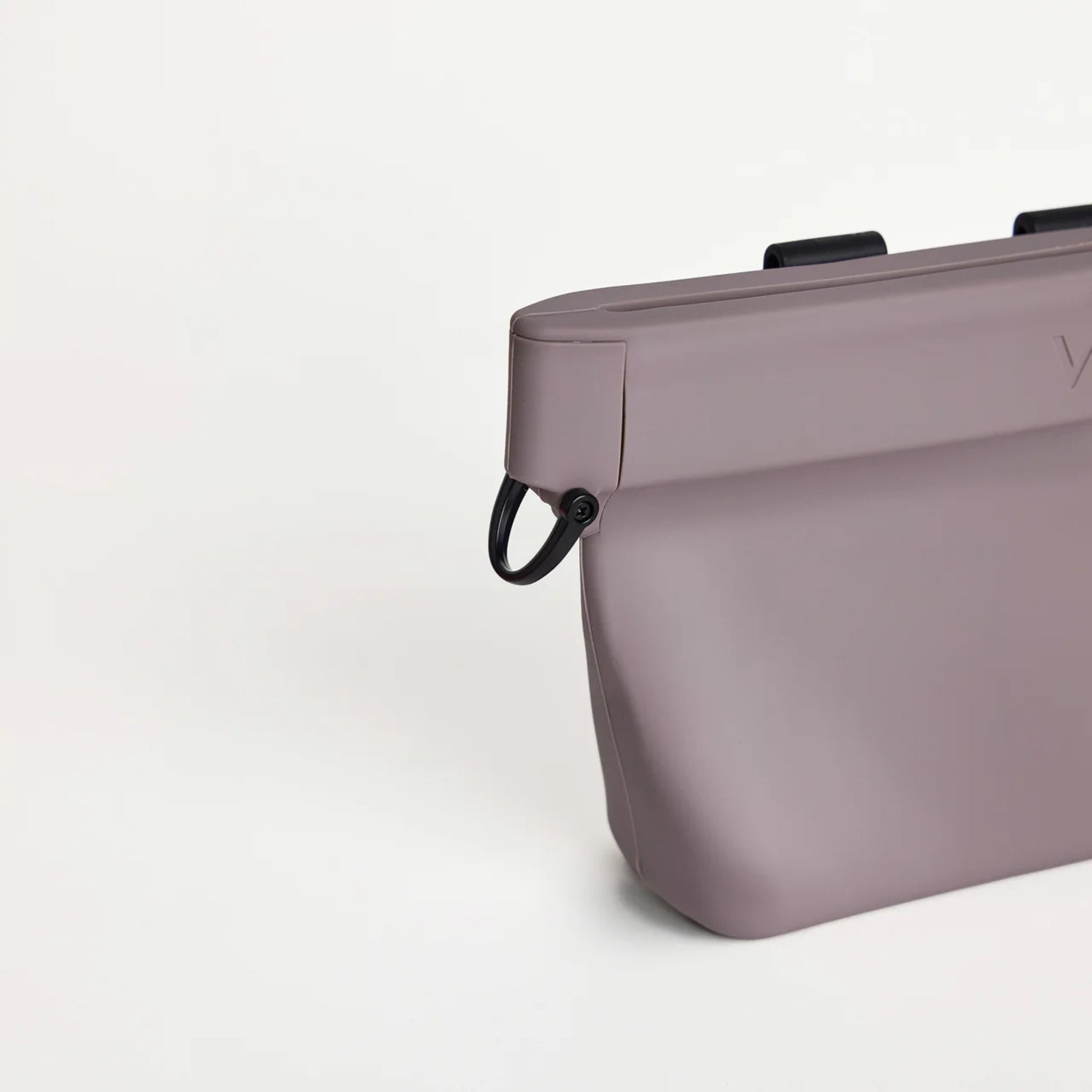 Close-up view of the black metal D-ring attachment clip on the side of the mist gray silicone Ultimate Treat Pouch The Standard by Voilapets.