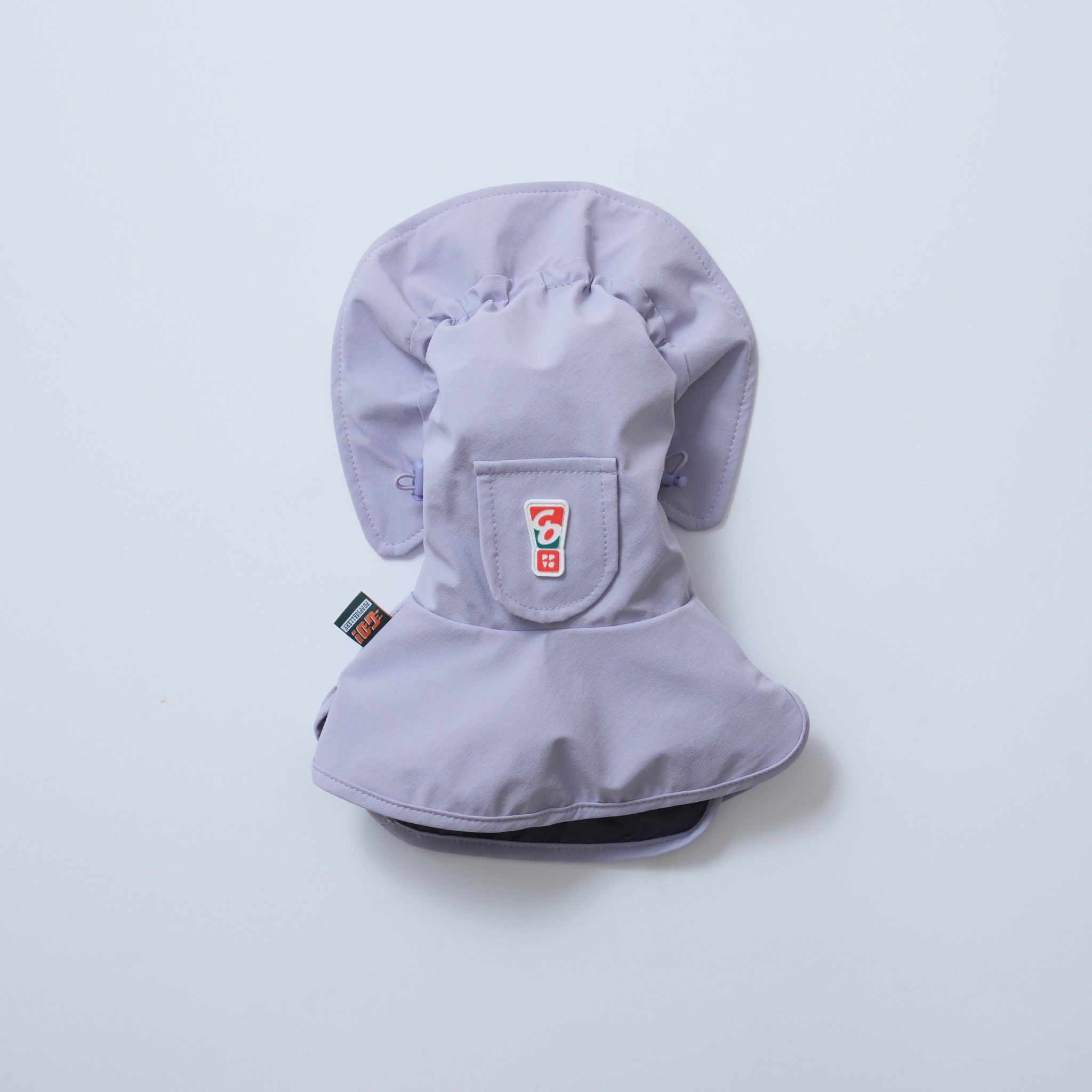 Back flat lay view of the lavender Puppy Gallery dog rain snood, highlighting the adjustable side toggle drawstrings, protective neck cape, and a small functional flap pocket with a graphic brand logo.