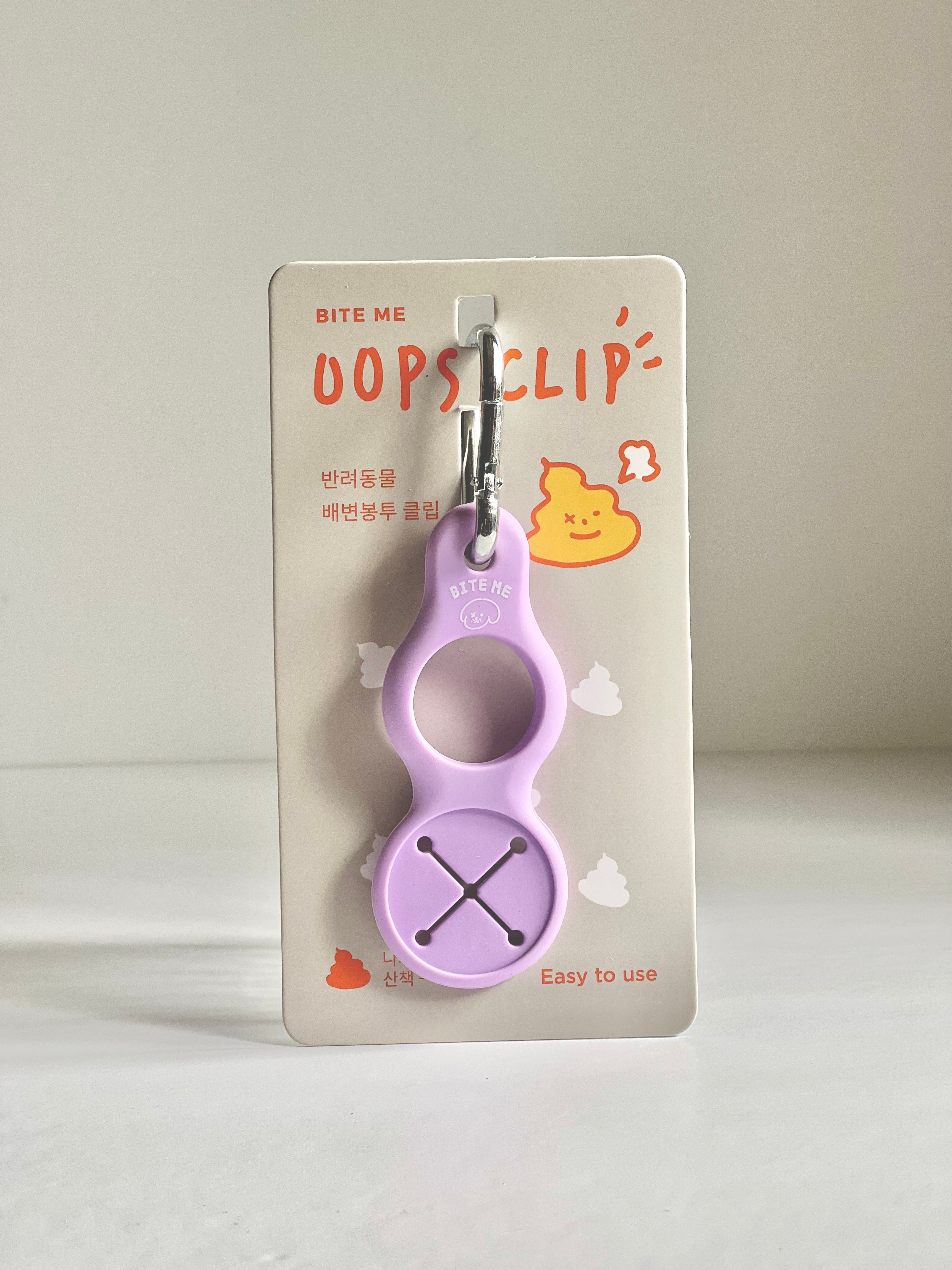 Bite Me Oops Clip Poop Bag Holder in Lavender, with a convenient carabiner clip and easy-to-use design, perfect for dog owners.